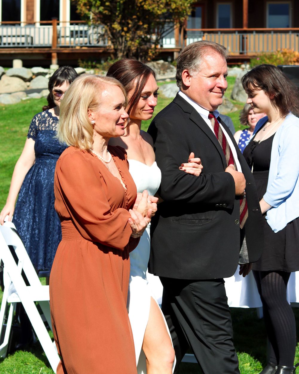 Wedding guests gathered outdoors on lawn during celebration.