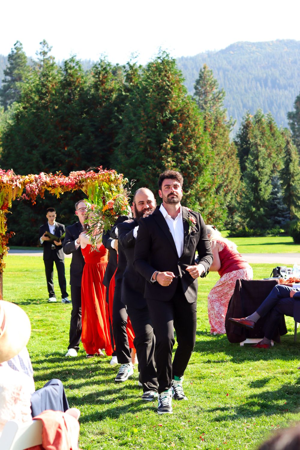 Joyful celebration on a lawn with mountain views and autumn decorations.