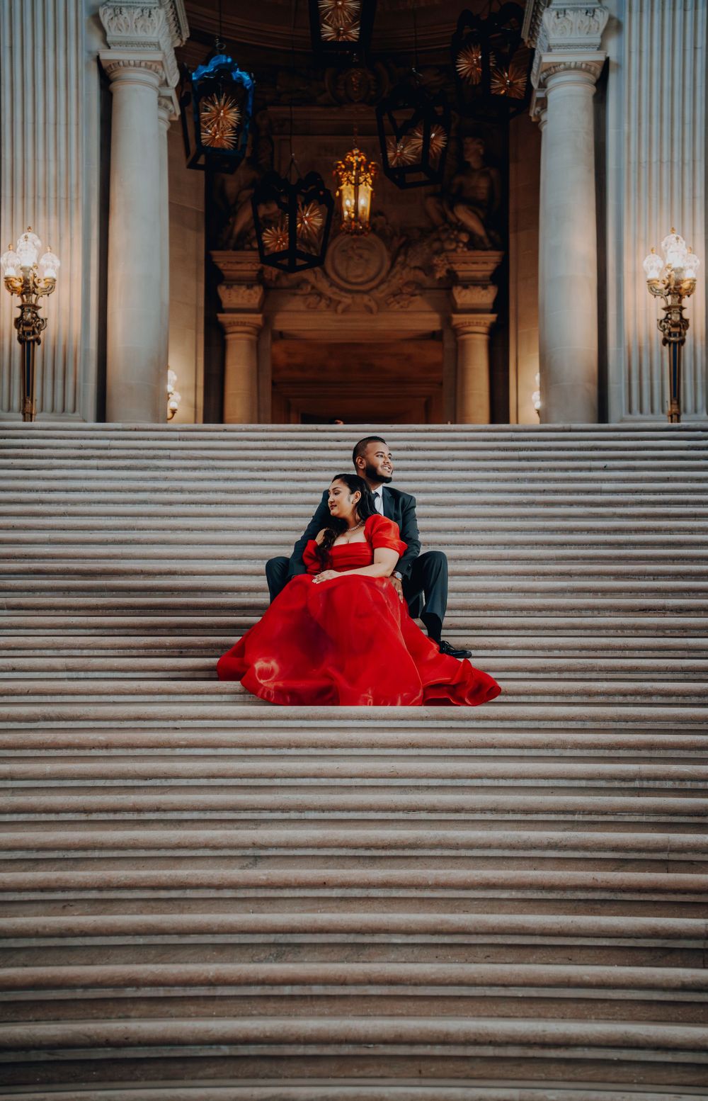 Romantic formal photoshoot on grand marble stairs with classical architectural details.