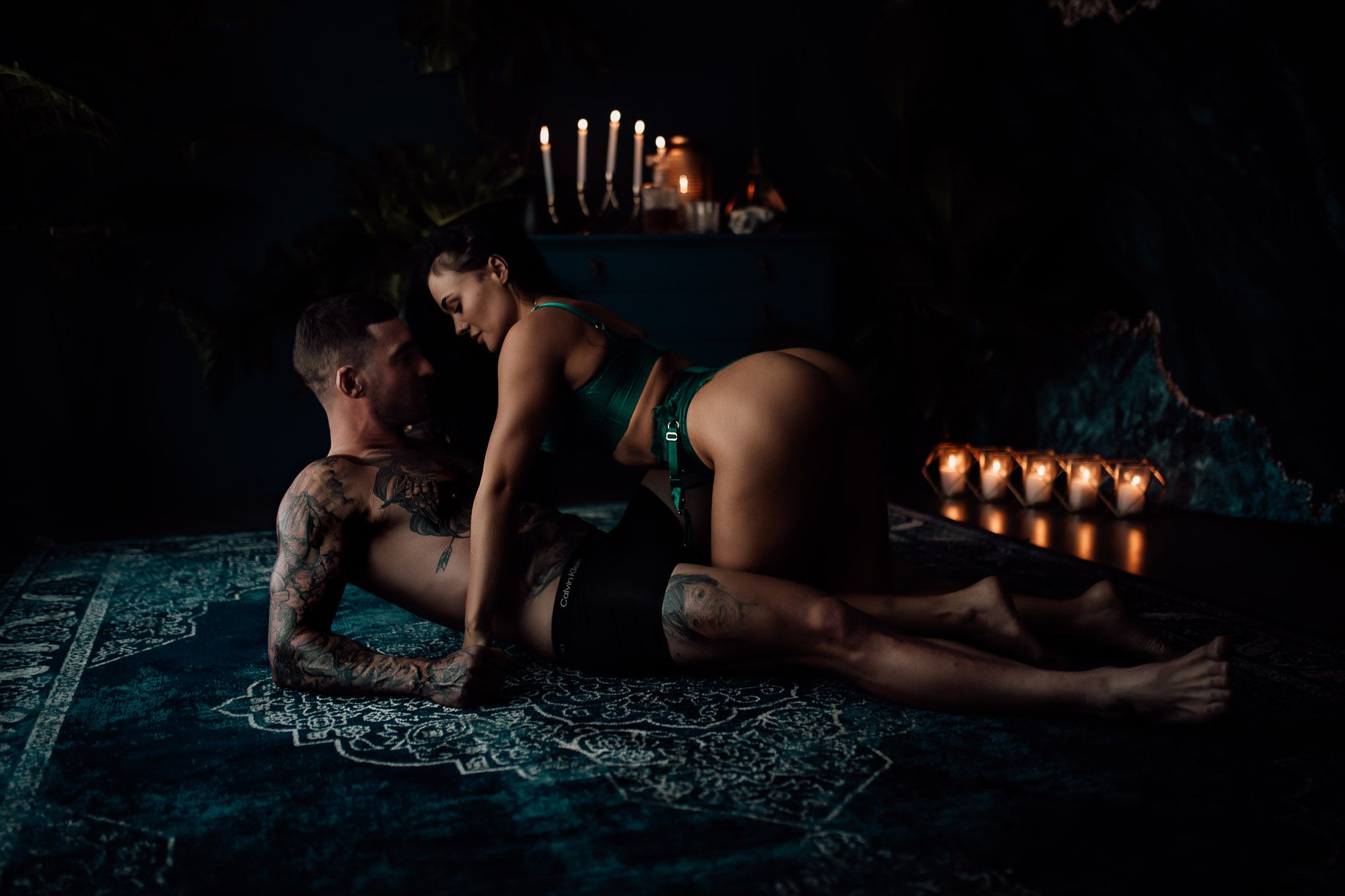 A romantic scene with candlelit ambiance and a patterned rug on the floor.