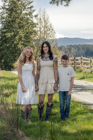 A tattooed mother posing with her teenage daughter and young son on a green country path in eatonville washington taken by roy photographer