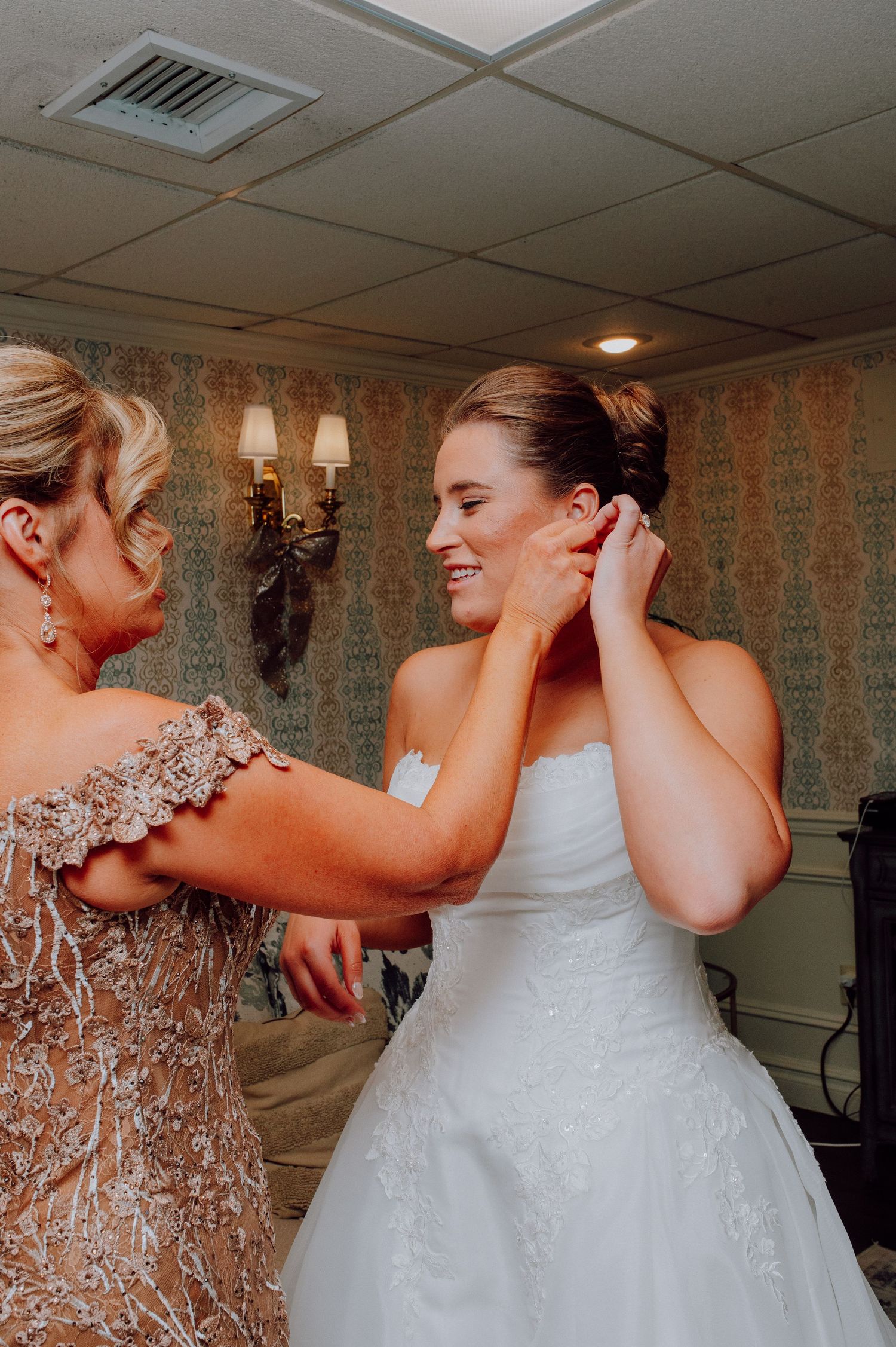 Bride getting ready at Olde Mill Inn bridal suite during winter wedding. Wedding dress hanging in window at Olde Mill Inn in Basking Ridge