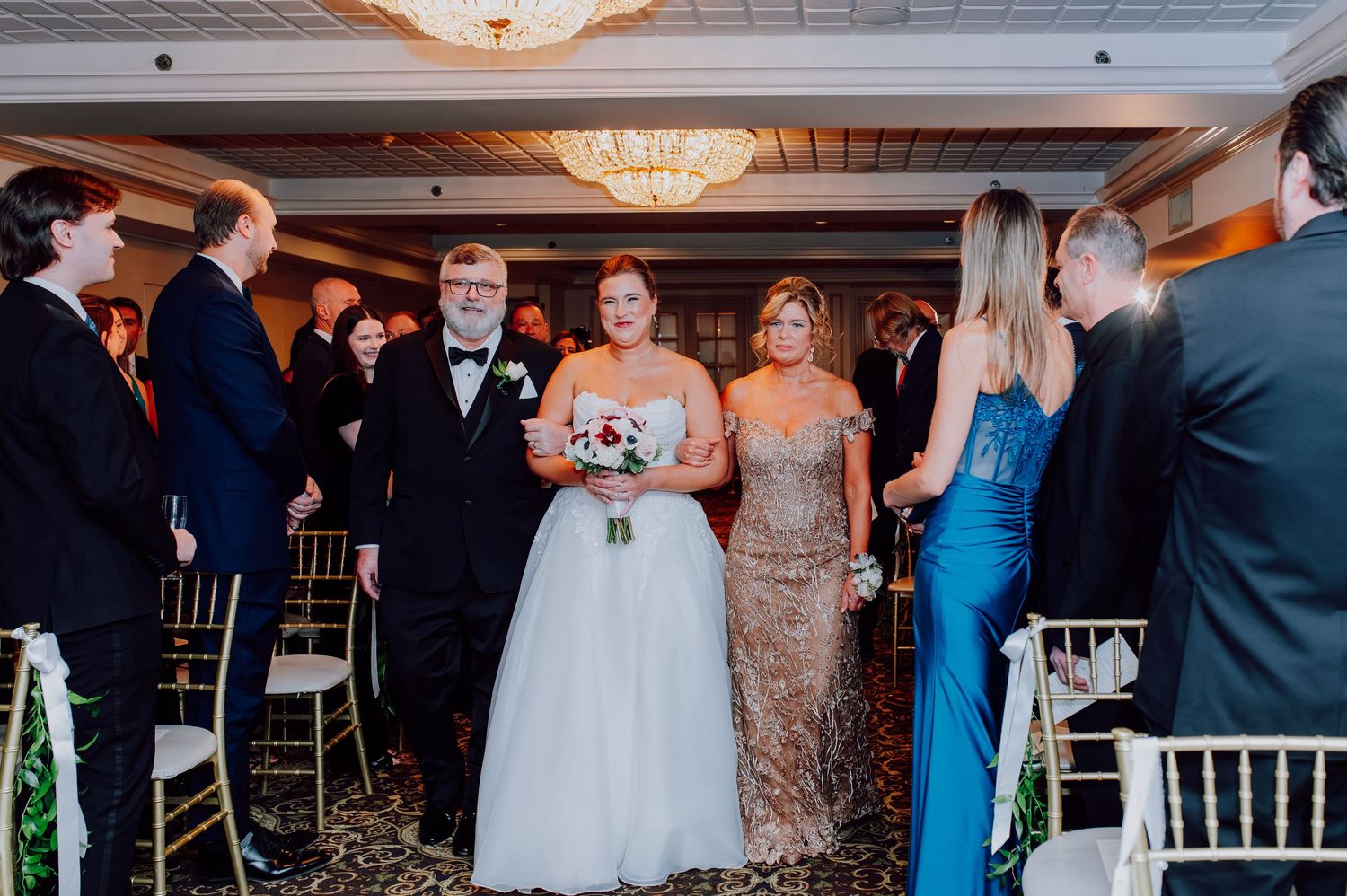 Indoor winter wedding ceremony at Olde Mill Inn Basking Ridge NJ with candlelight.Bride walking down aisle