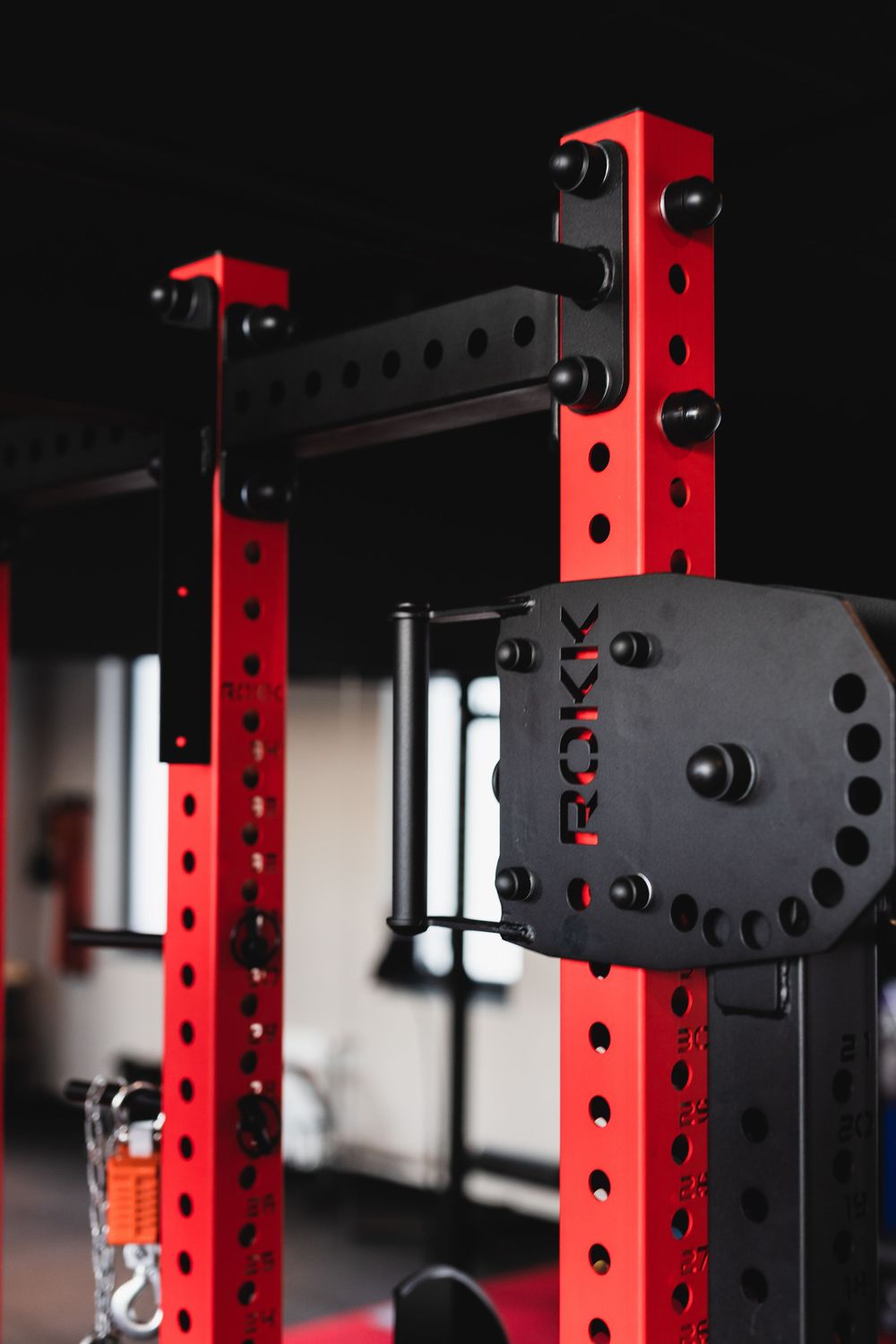 ROKK power rack czerwono-czarny w siłowni, stalowa konstrukcja i wyciąg. Fotografia biznesowa Lublin.