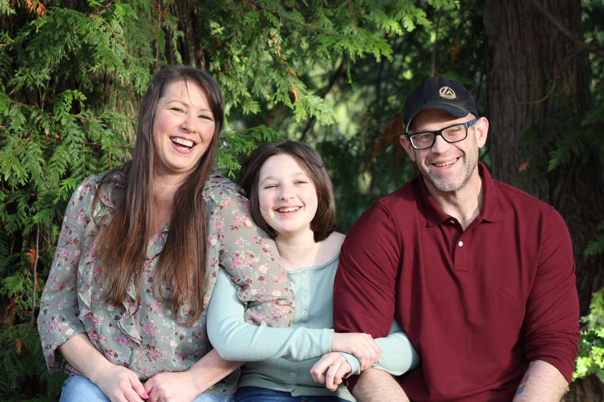 Smiling family sitting together outdoors sharing a joyful and candid moment during a photo session