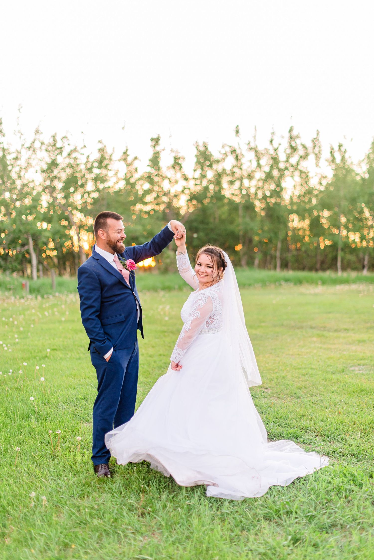 Bride and groom share their first dance on a wooden floor at a wedding reception with fairy lights in the background.