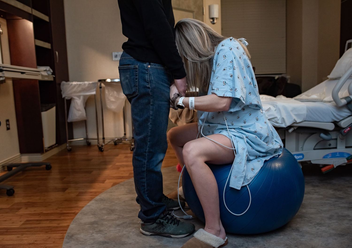 A a laboring mom sitting on an exercise ball during labor.