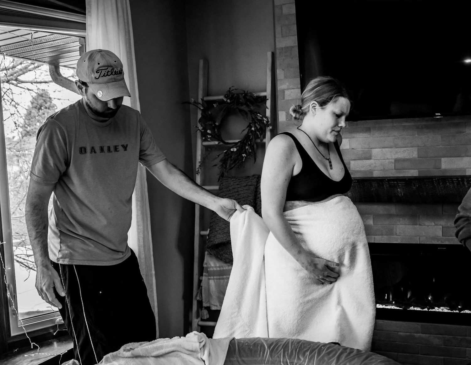 Person in labor receives support while standing beside birthing pool at home.