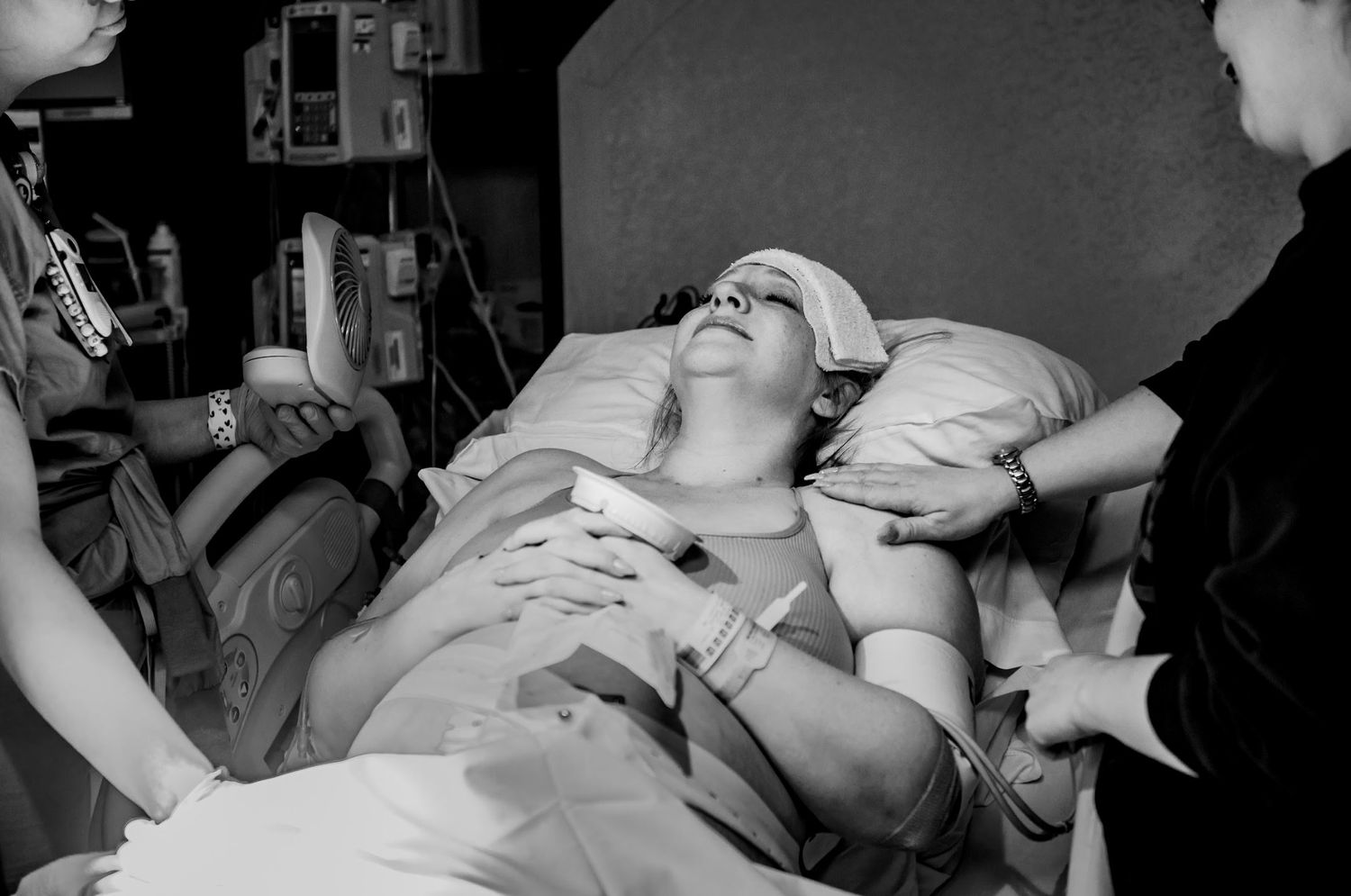 Medical professionals attend to a patient during labor after she learns she will need a c-section