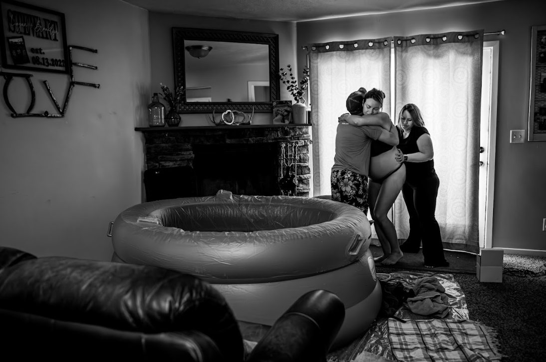 A series of people helping to inflate and set up a large blue inflatable pool in an indoor space.