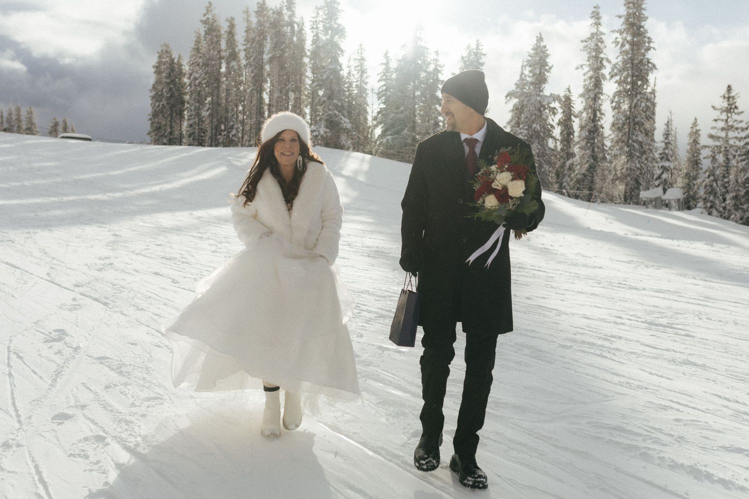 bride and groom walk across the snowy ski hill during their Revelstoke elopement