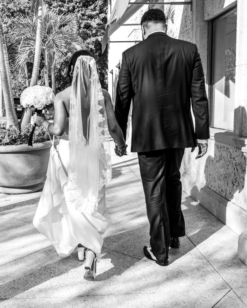 Romantic couple walking through Palm Beach during wedding portrait session