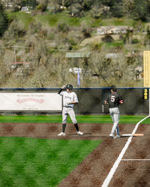Two baseball players in white pinstripe uniforms stand near first base during an outdoor game on a sunny day.