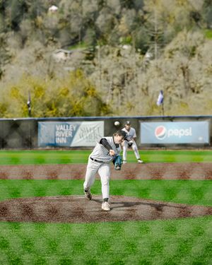 Baseball pitcher in white pinstripe uniform delivers a pitch with a Pepsi advertisement visible on the outfield wall.