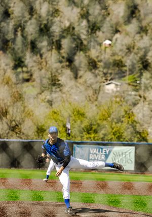 Baseball pitcher in blue uniform follows through on a pitch at Valley River field.