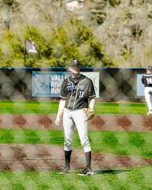 Baseball player wearing Titans jersey number 11 stands on field during a game at an outdoor ballpark.