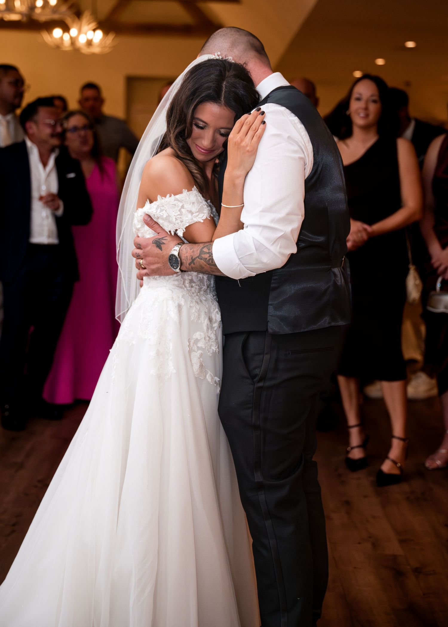 Bride and groom share an emotional first dance embrace at their wedding reception.