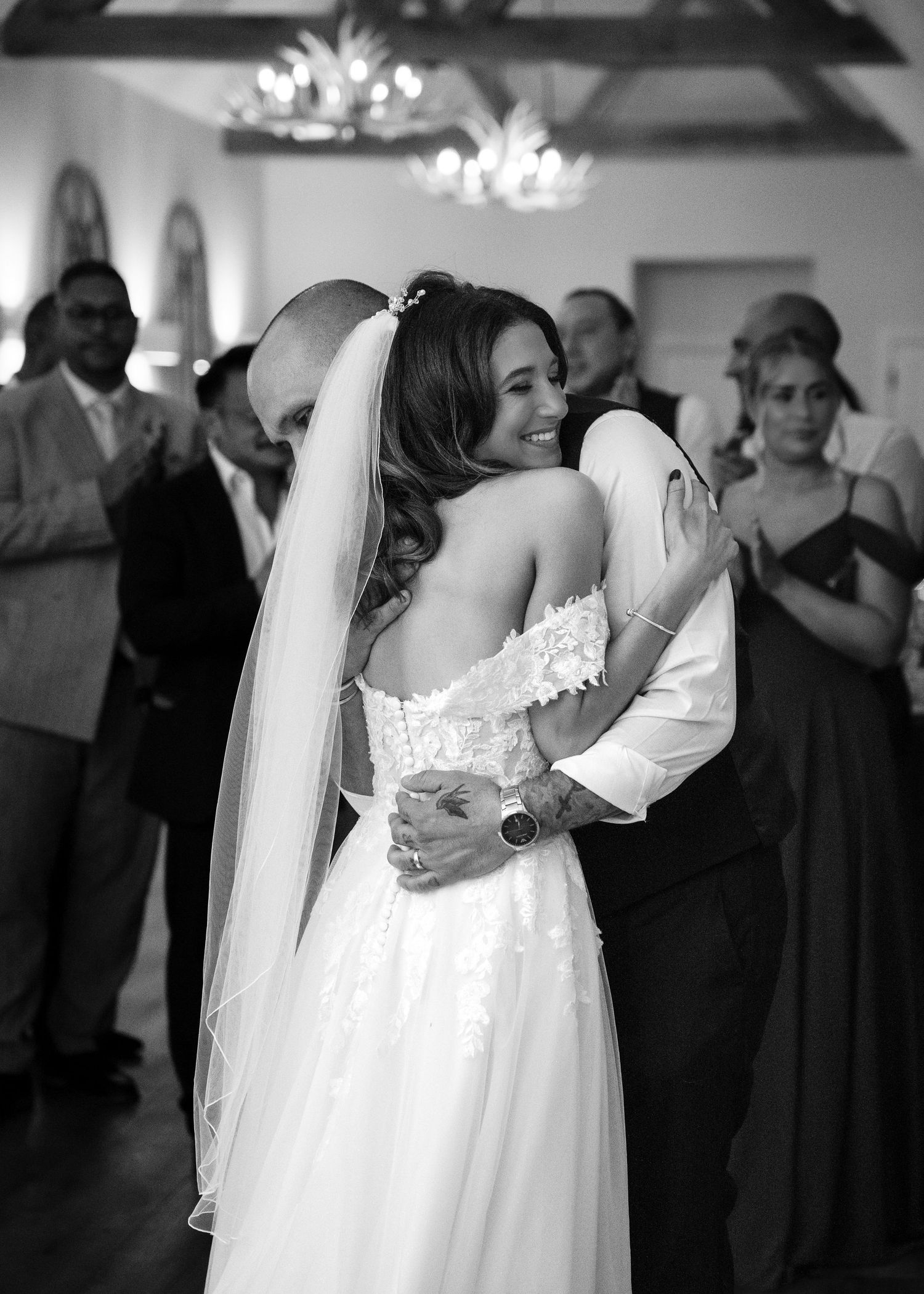 Black and white photo of bride and groom sharing first dance at wedding reception.