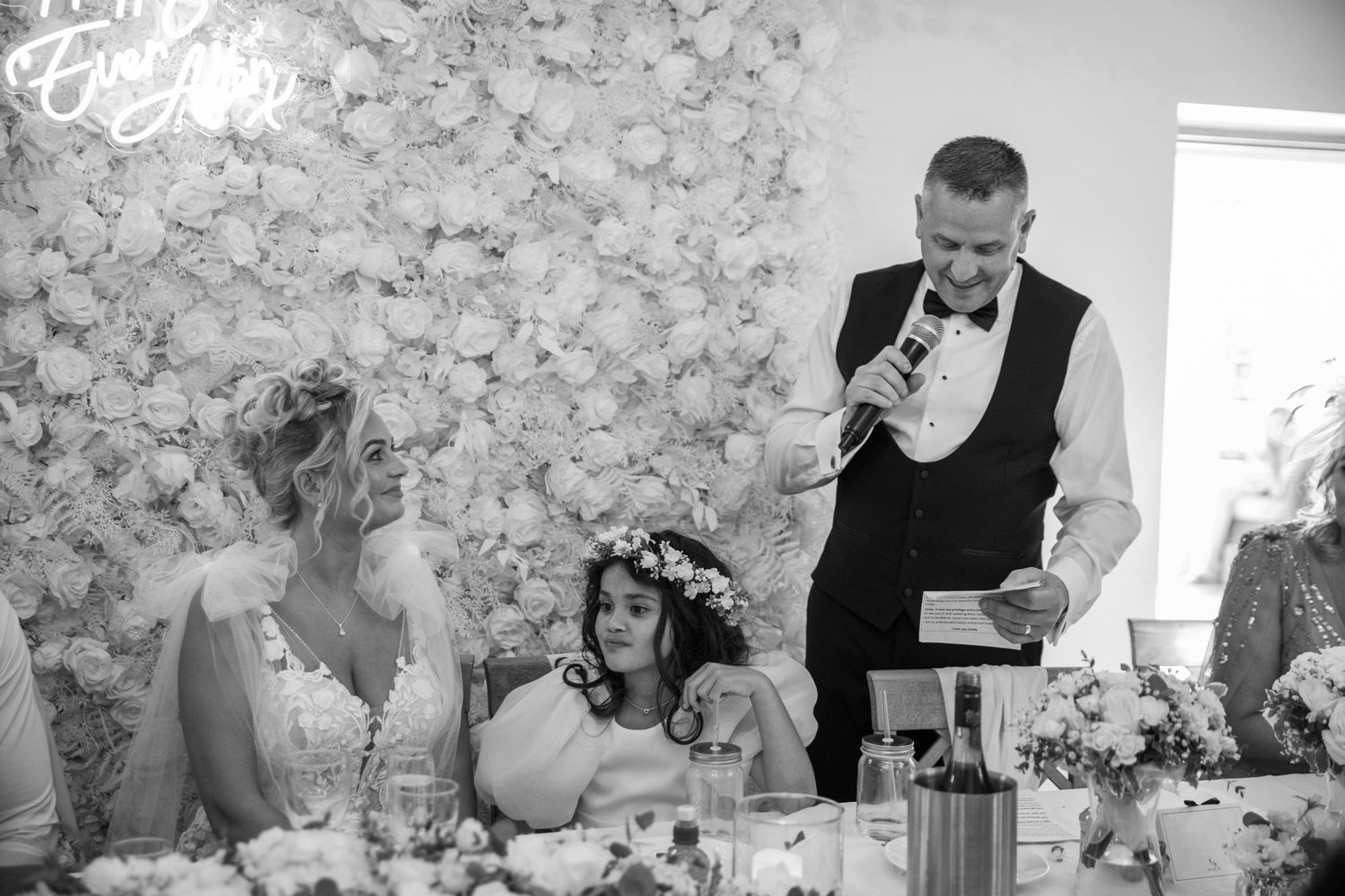Black and white photo series showing emotional reactions and candid moments during a wedding reception speech.
