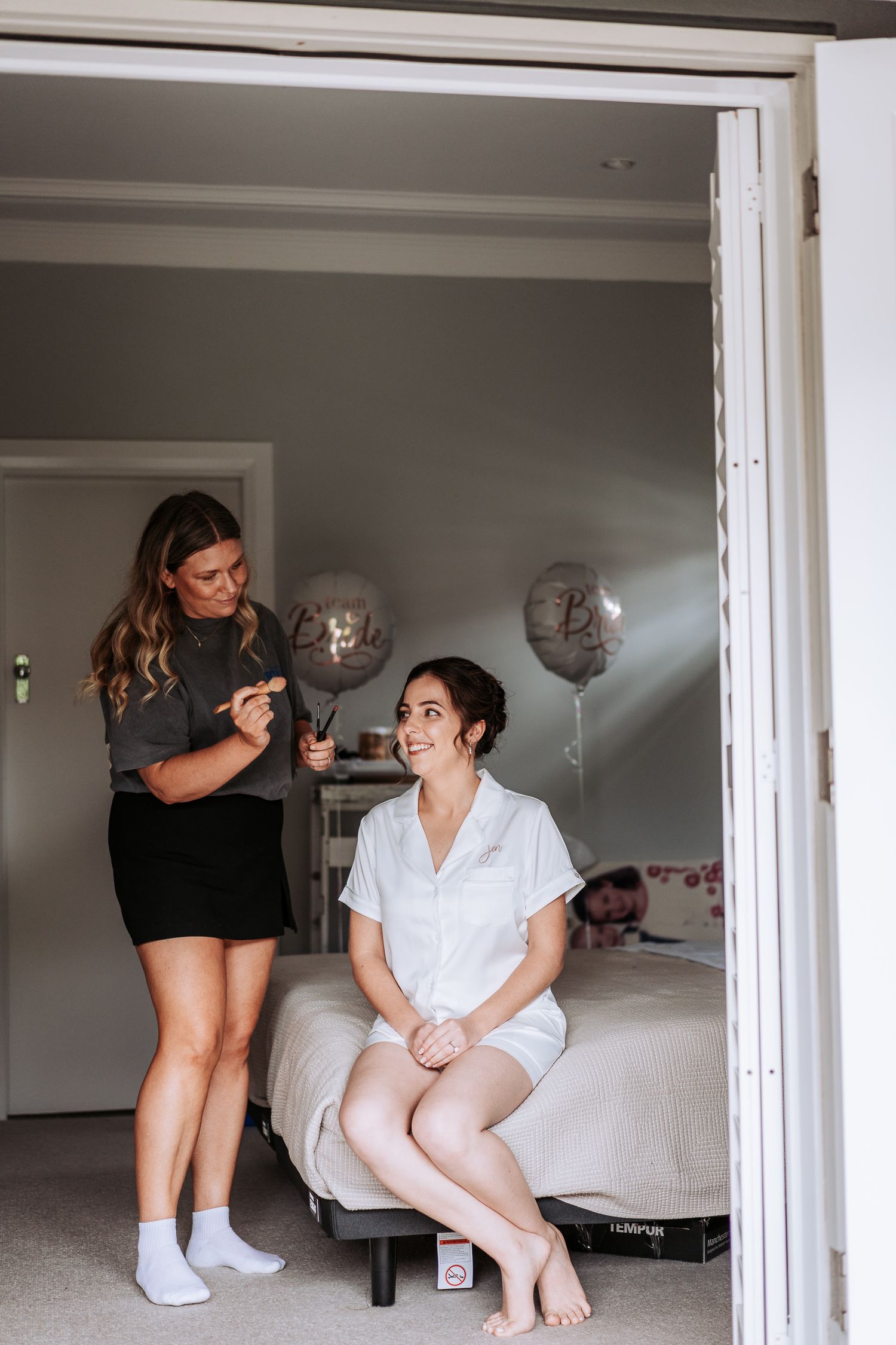 A sequence of photos showing two people sitting on a bed in a bright white room.