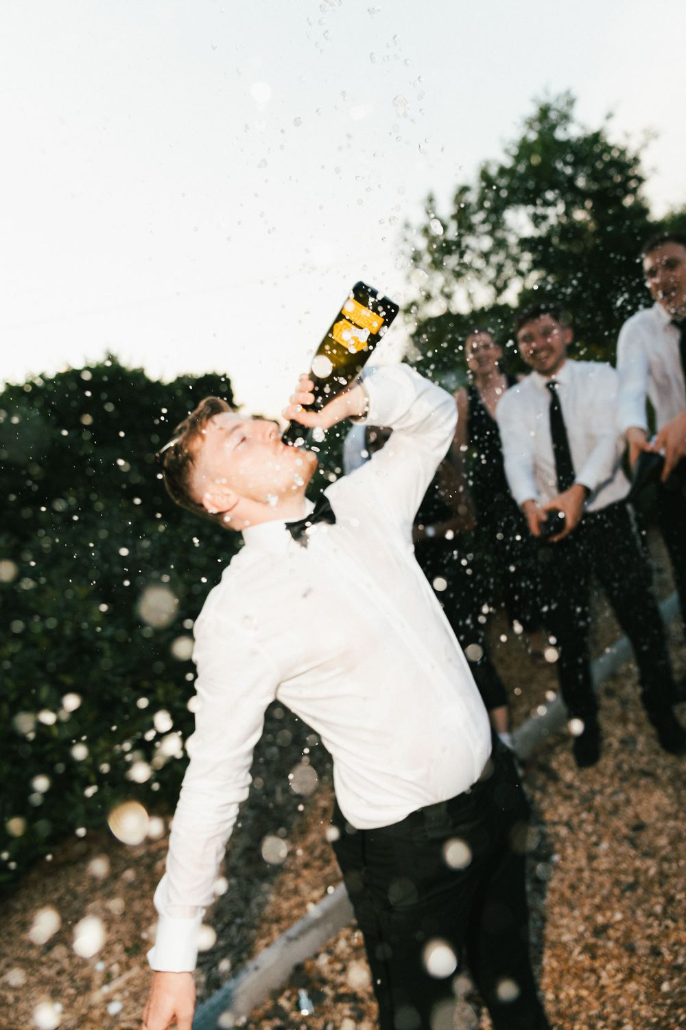 A series showing someone spraying and drinking champagne at an outdoor celebration.