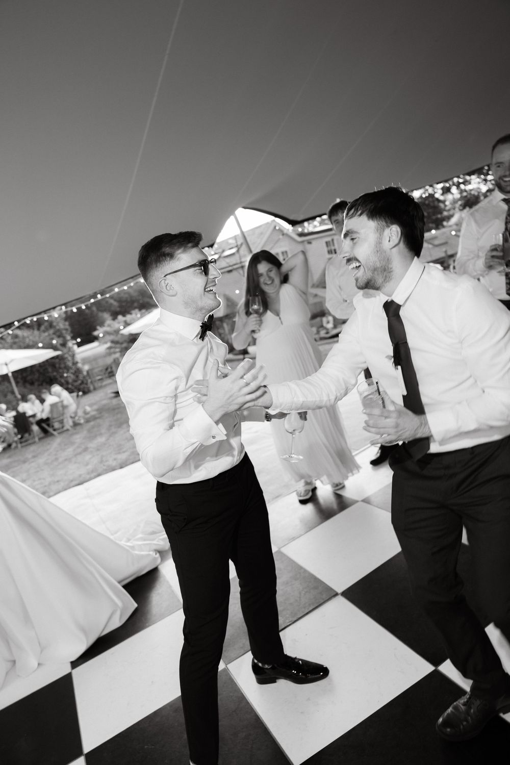 Black and white photos of people dancing and celebrating at an outdoor event.
