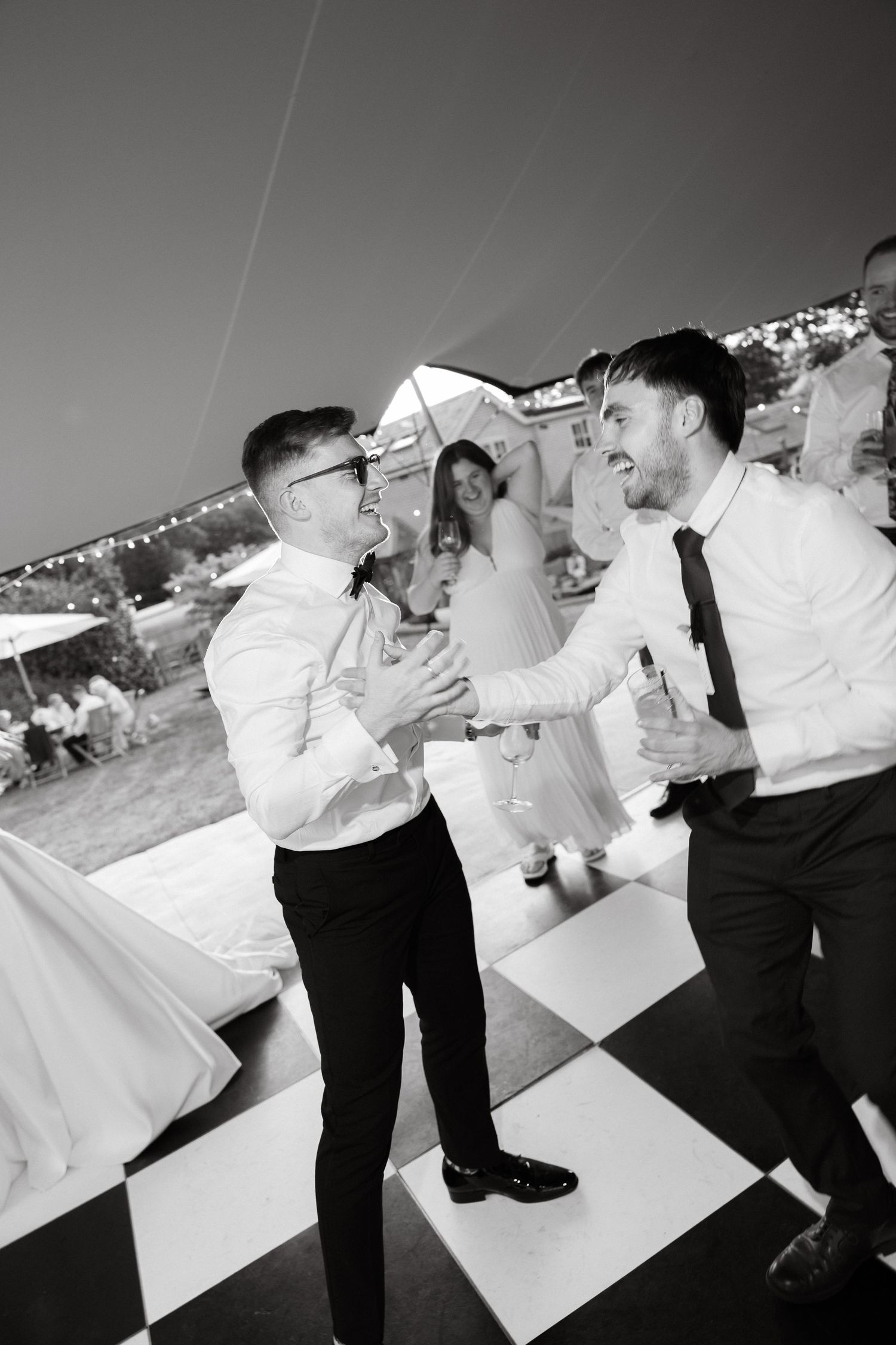 Black and white photos of people dancing and celebrating at an outdoor event.