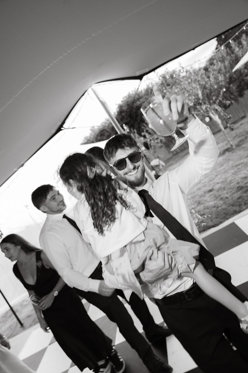 Black and white photos showing guests mingling and celebrating at an outdoor party.
