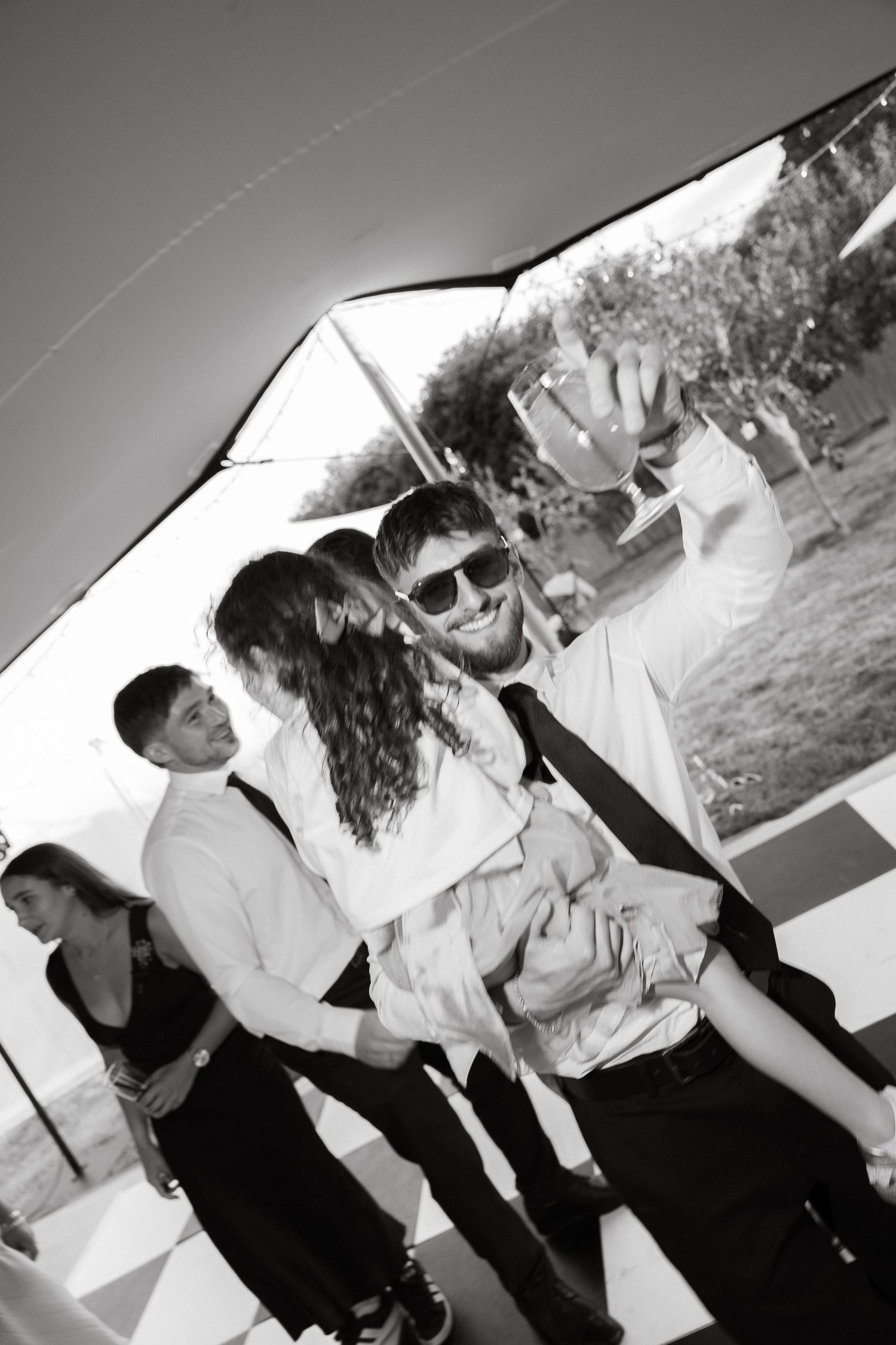 Black and white photos showing guests mingling and celebrating at an outdoor party.