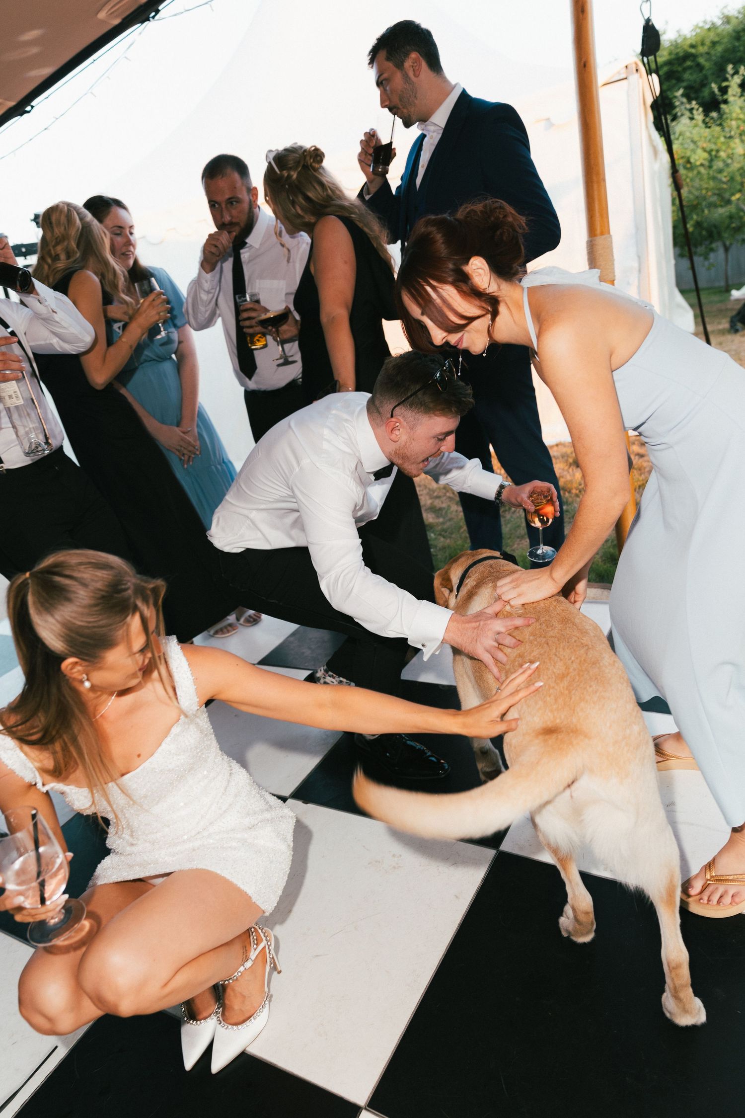 Party guests dancing and celebrating on a white dance floor at an outdoor event.