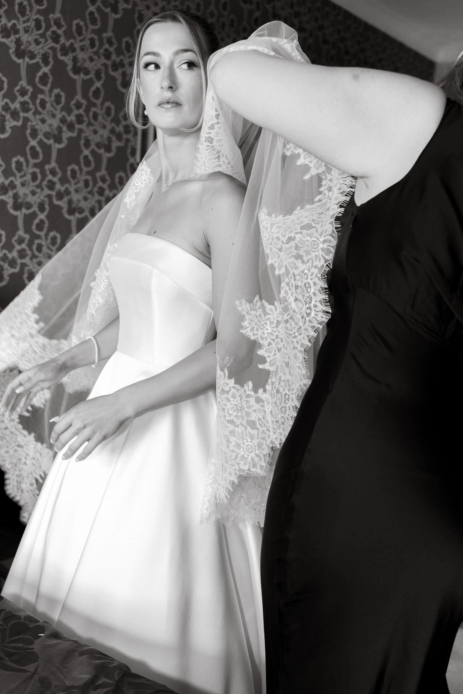 Elegant bridal portrait in classic white wedding gown with lace veil.