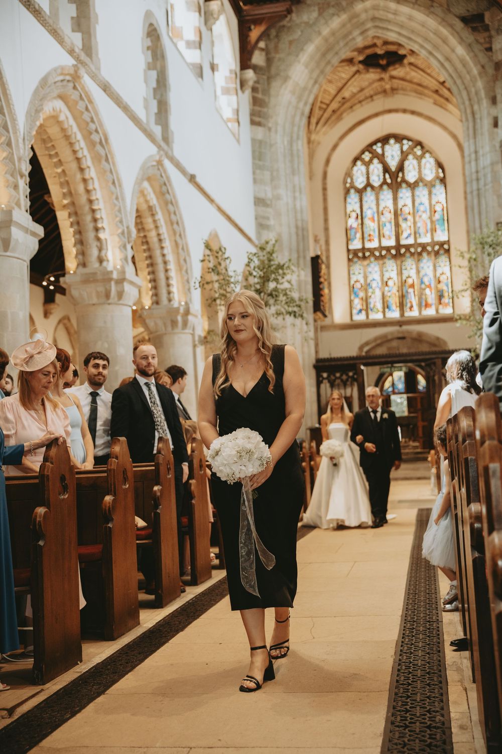 Wedding ceremony preparations in a grand cathedral with Gothic architecture and stained glass windows.