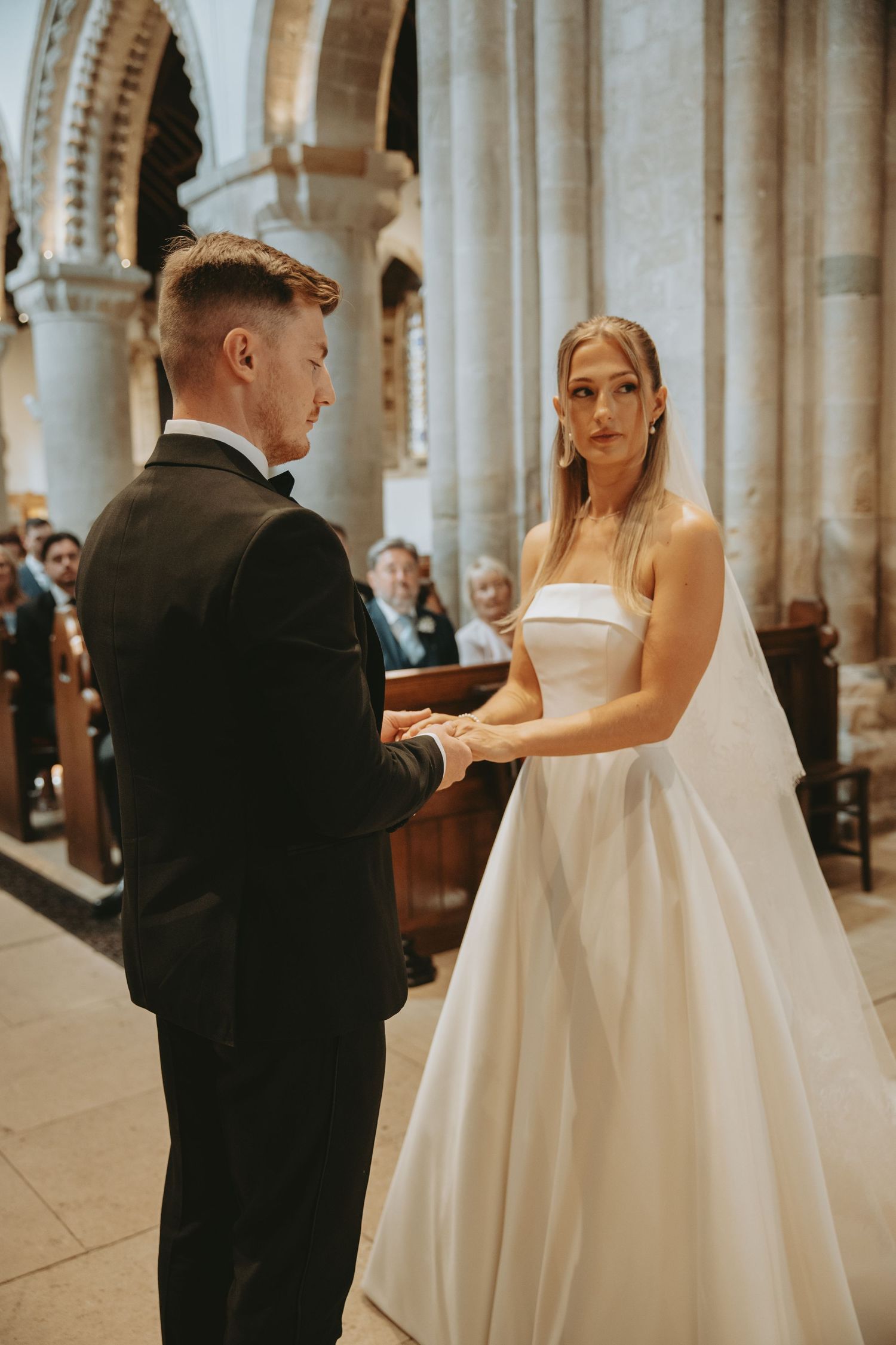 Couple dancing in an elegant church setting with ornate architectural details and columns.
