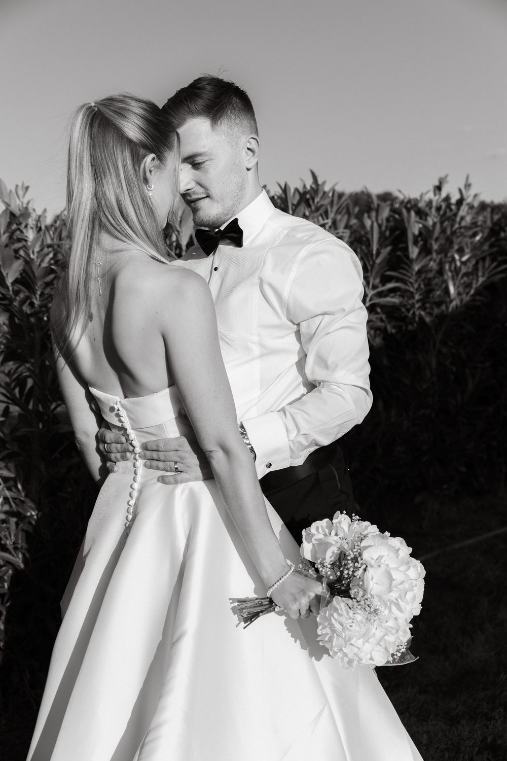 Romantic black and white wedding photos showing details of elegant bridal dress.