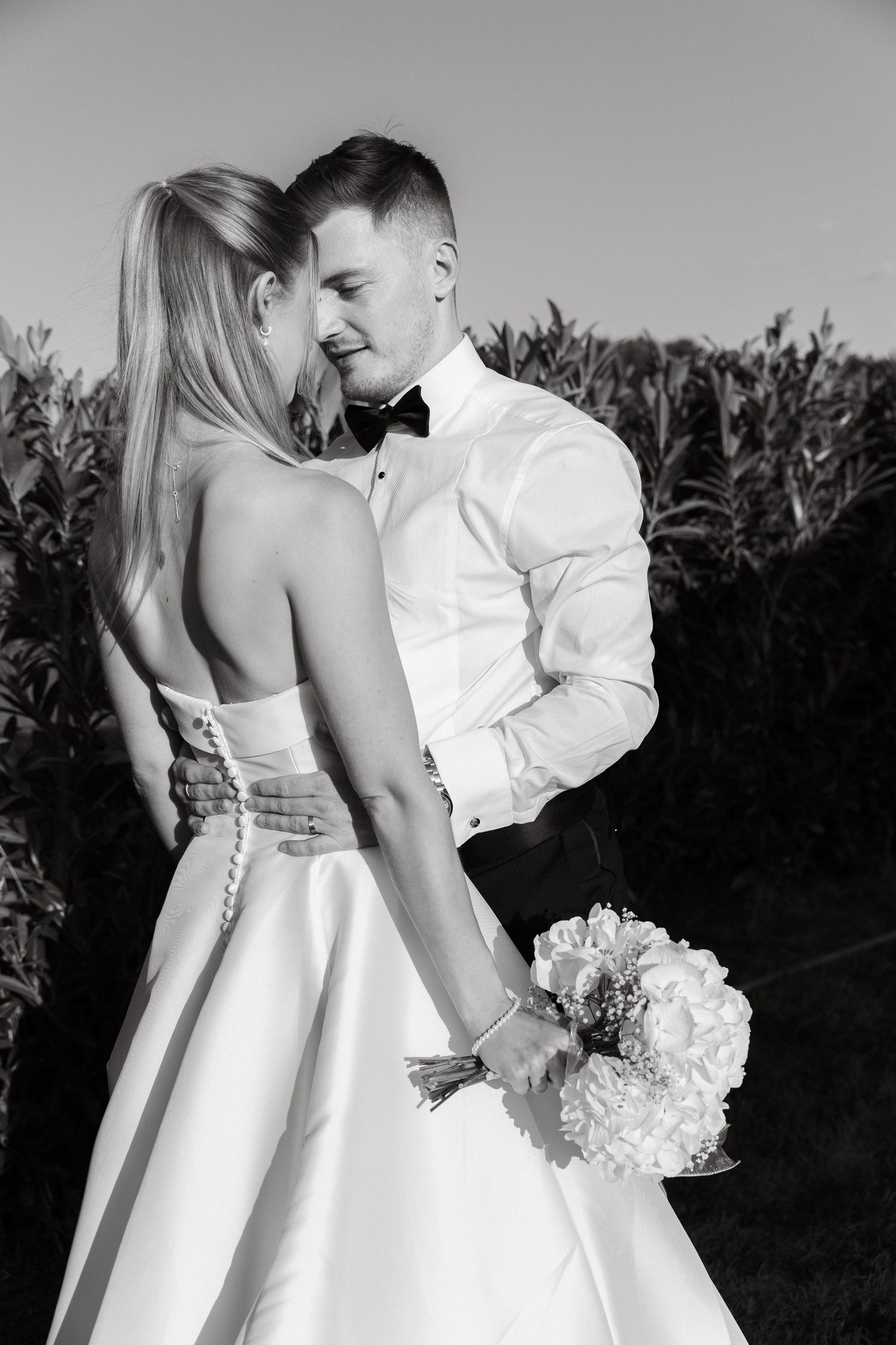Romantic black and white wedding photos showing details of elegant bridal dress.