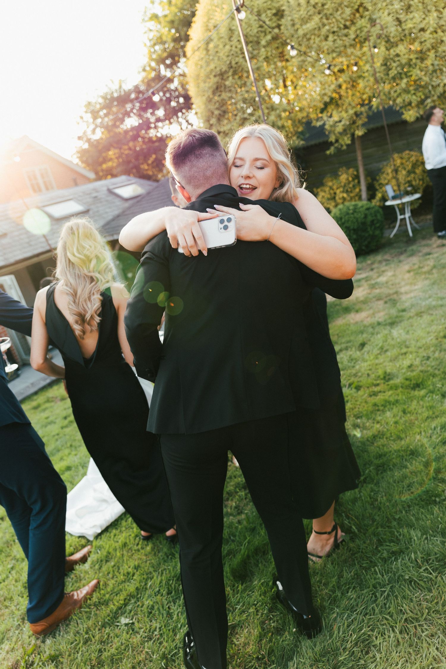 Playful group photos taken on a grassy lawn during a formal event.