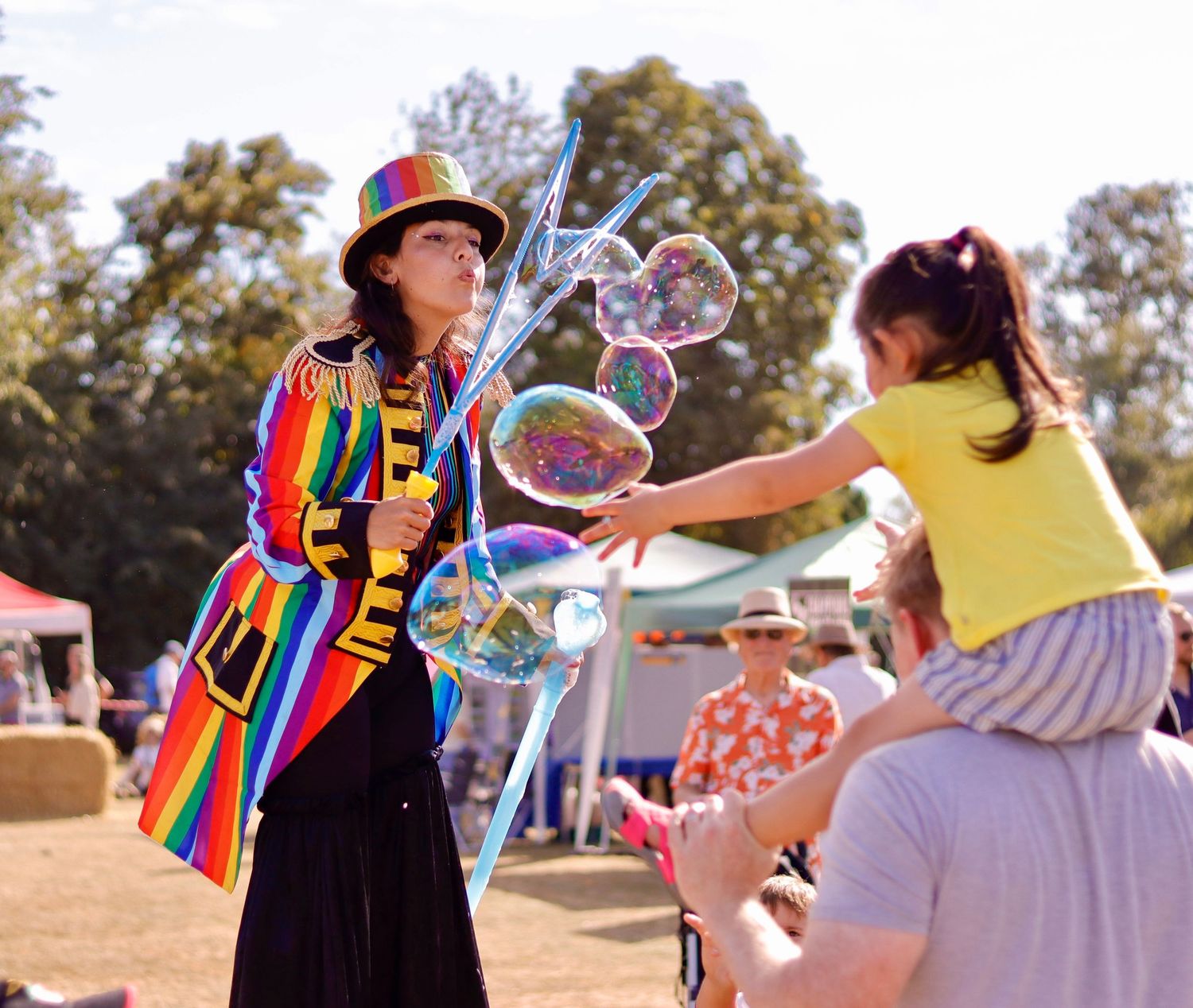 Event animator making bubbles to entertain a child at the village fete.  Perfect photo shoot.