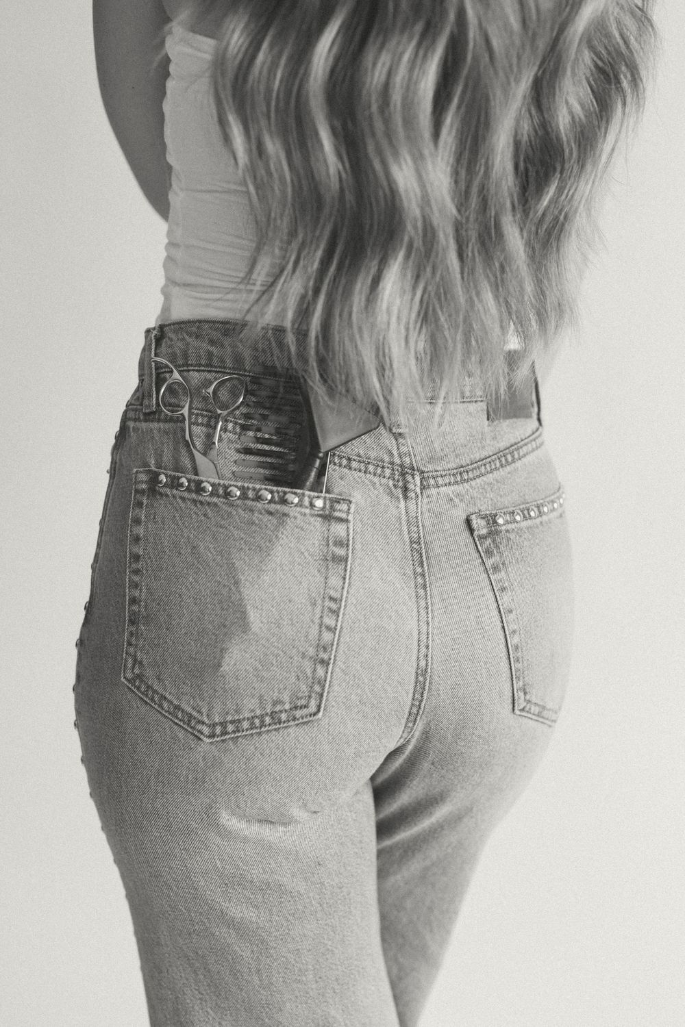 Back view of light wash vintage-style denim jeans showing pocket details against a white background.