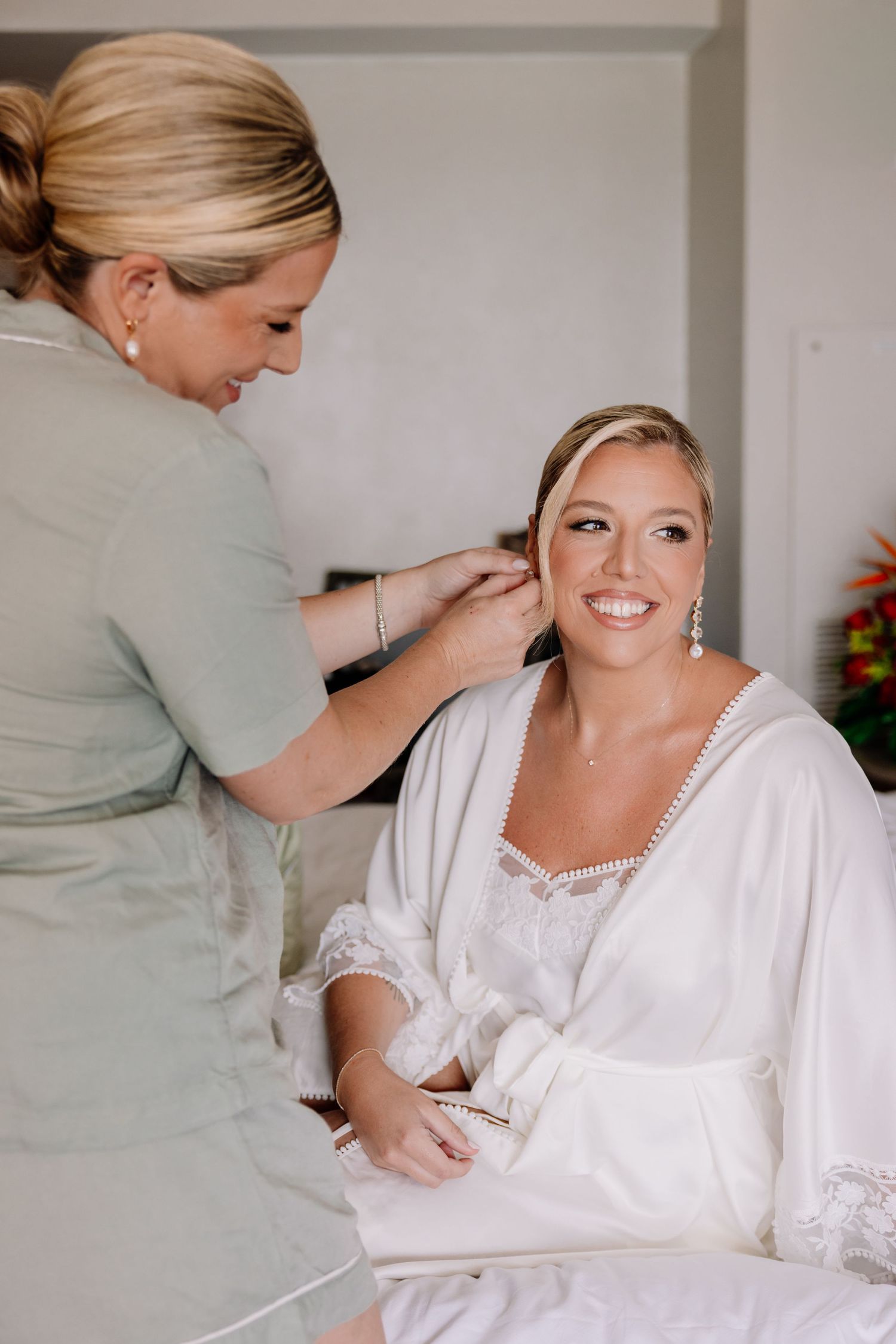 Bridal preparations with white lace robe and elegant styling.
