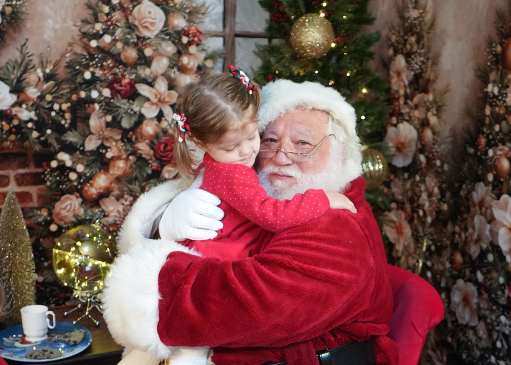 A heartwarming holiday scene shows warm embraces near a decorated Christmas tree with twinkling lights and ornaments.