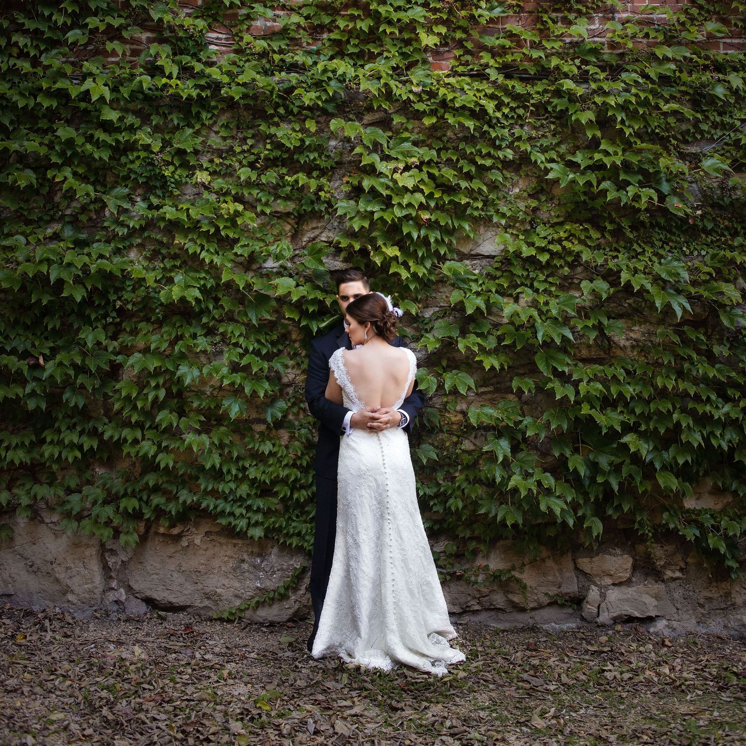 Vintage wedding at the Hotel Julien in Dubuque, Iowa. Bride and groom standing next to a wall covered in ivy.