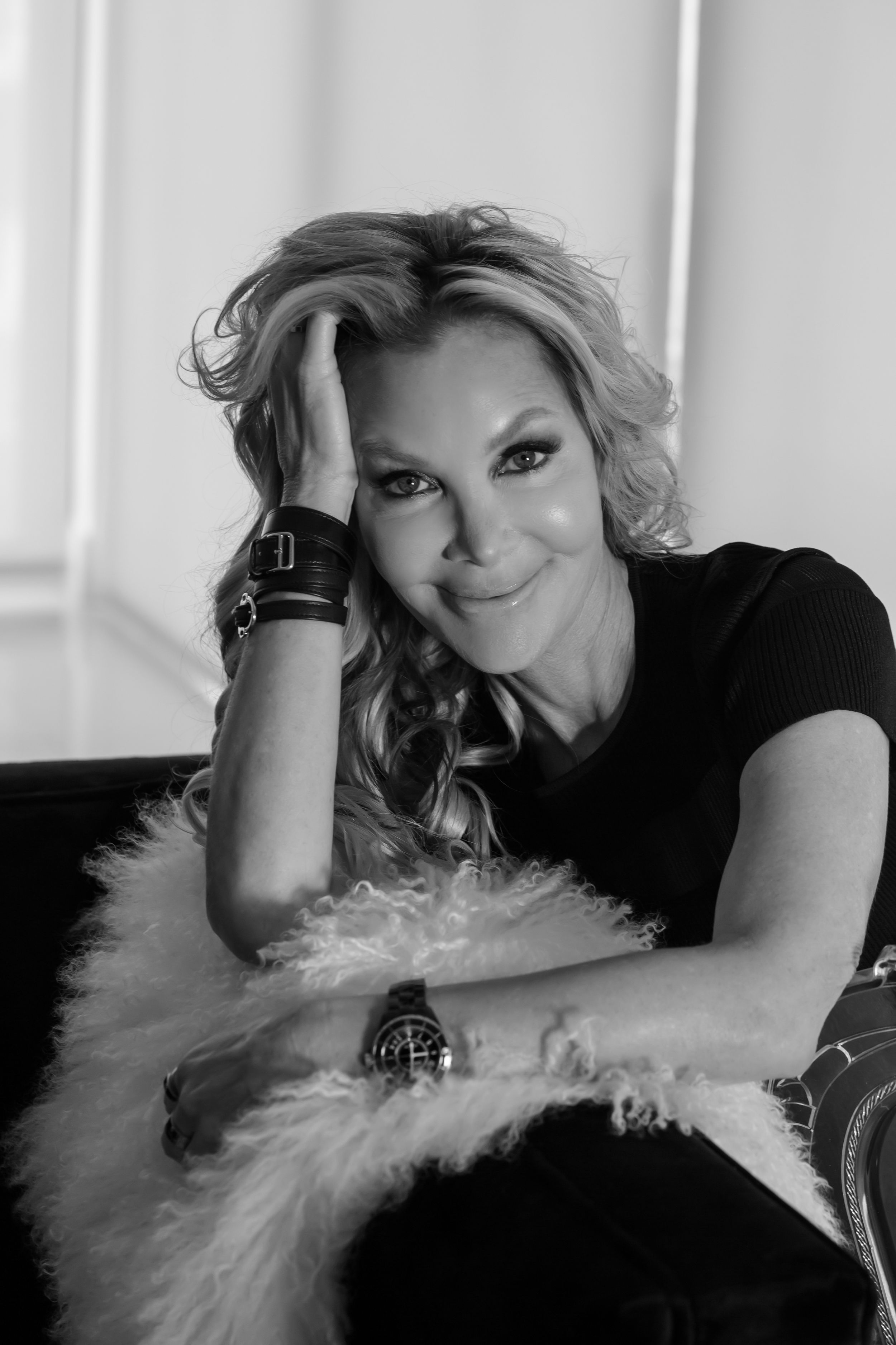 A glamorous black and white photo series showing someone posing dramatically with white feathers against a light background.