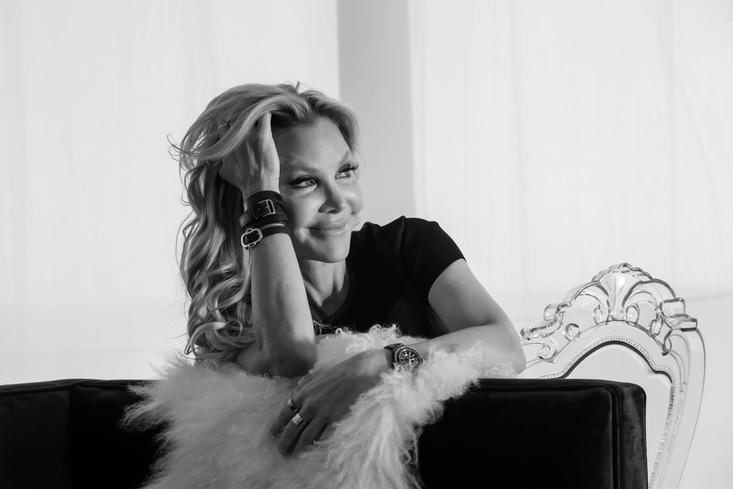 A series of black and white boudoir photos showing a person lounging on a couch in romantic poses.