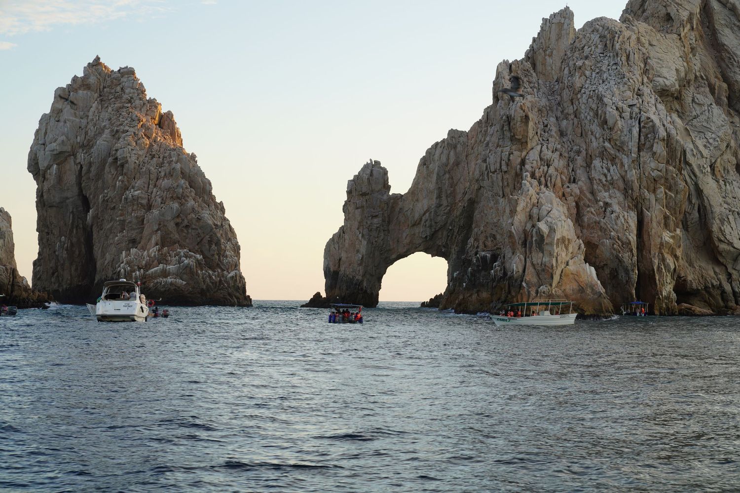 Rocky cliffs and natural stone arches rise from the ocean at Lands End in Cabo San Lucas, Mexico.