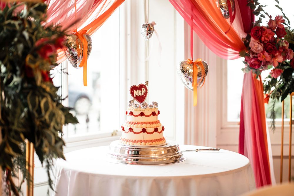 Red and white wedding decor with hanging floral arrangements and romantic lighting creates an elegant reception atmosphere.