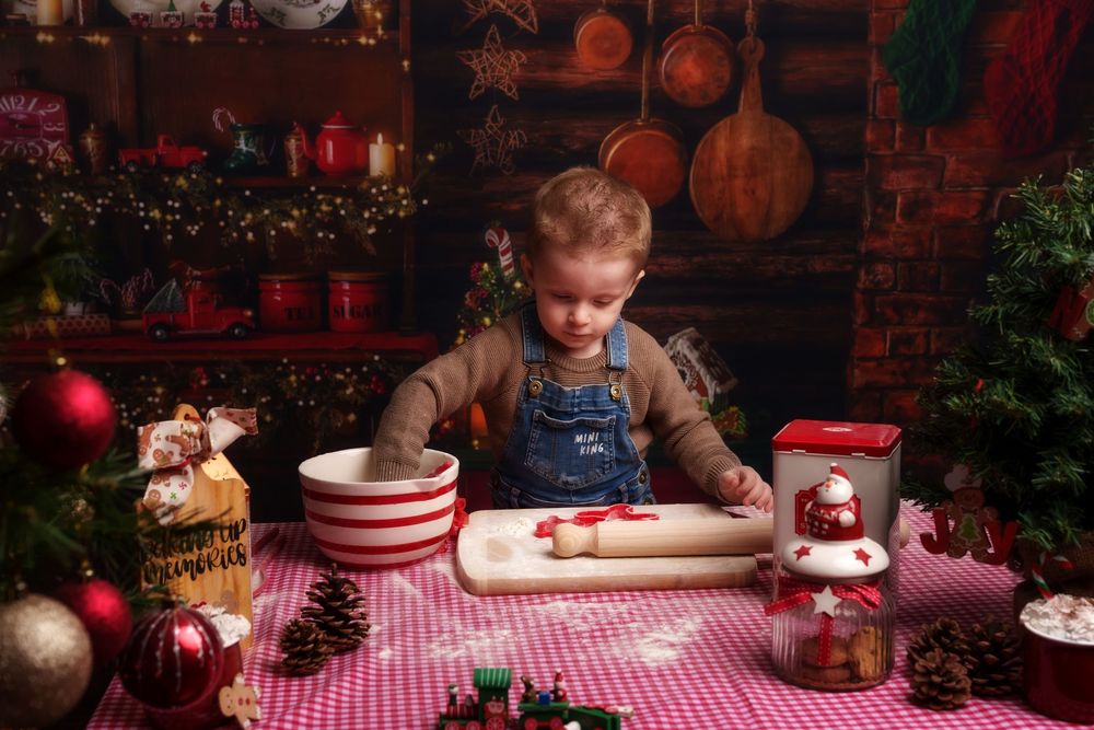 Children decorate Christmas cookies with red and white frosting at a festive table with holiday decorations.