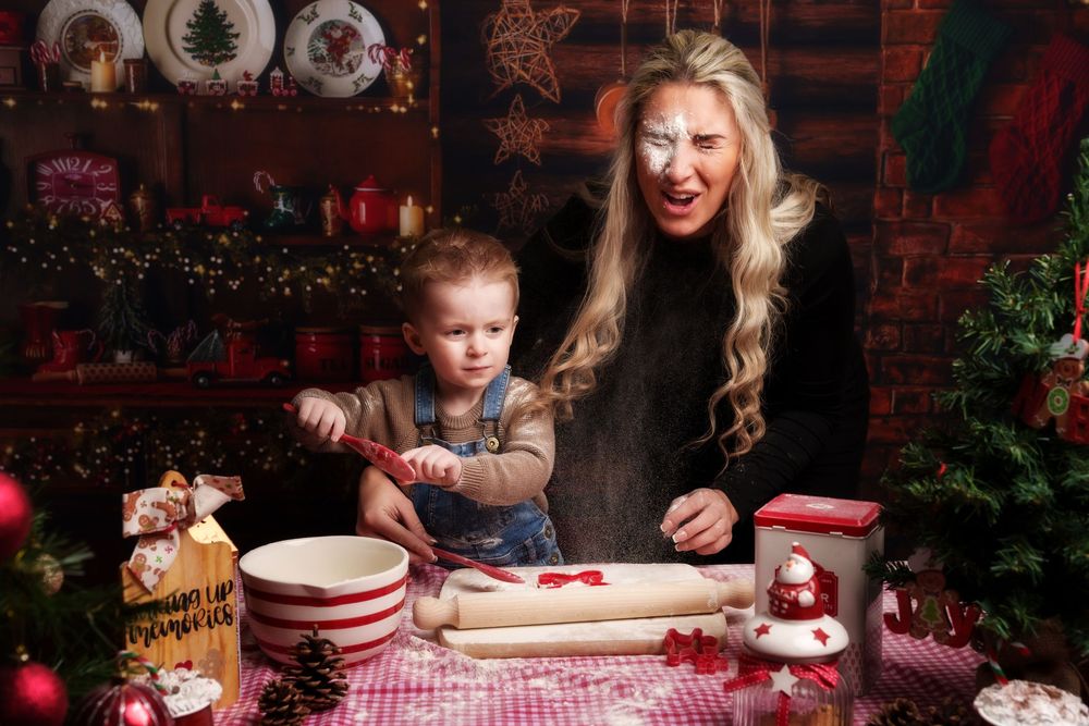 Family enjoying holiday treats and hot cocoa at a festive table with red checkered tablecloth and Christmas decorations.