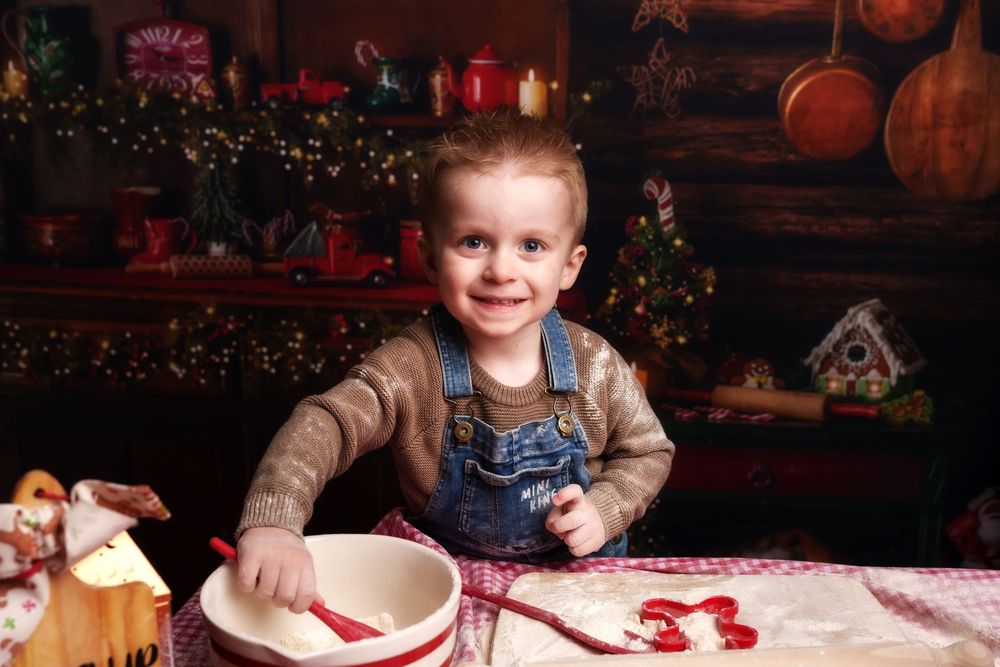 Festive holiday scene with denim overalls and cozy Christmas decorations including pumpkins and twinkling lights in background.