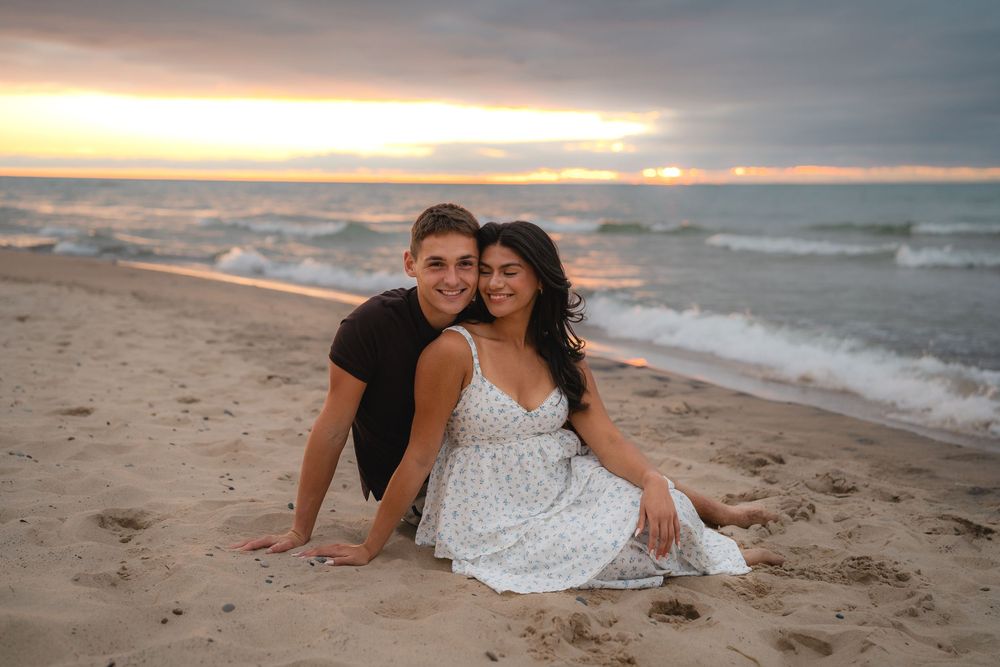 Two people share a romantic moment on the beach at sunset.
