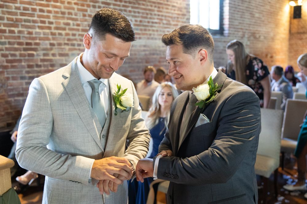 The Groom and his Best Man sharing laughter and just before the wedding ceremony in the barn at Cooling Castle.